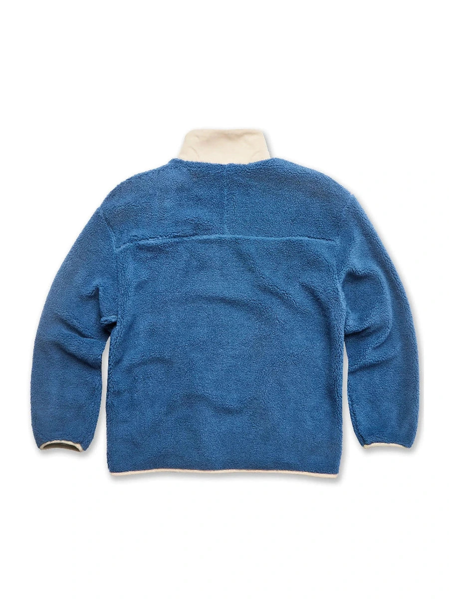 Blue fleece jacket with white trim on a white background