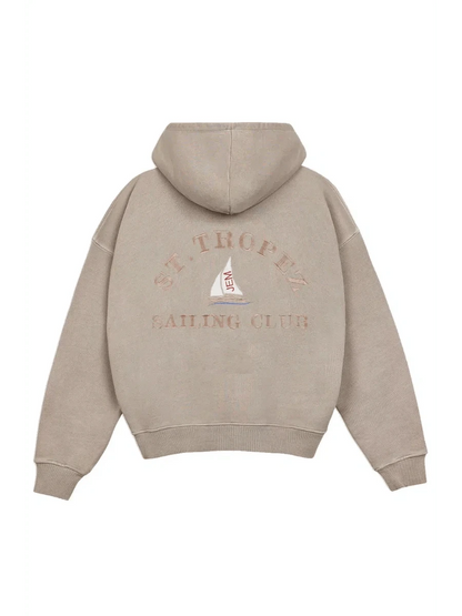 Beige hoodie with 'St. Tropez Sailing Club' text and logo on the back against a white background